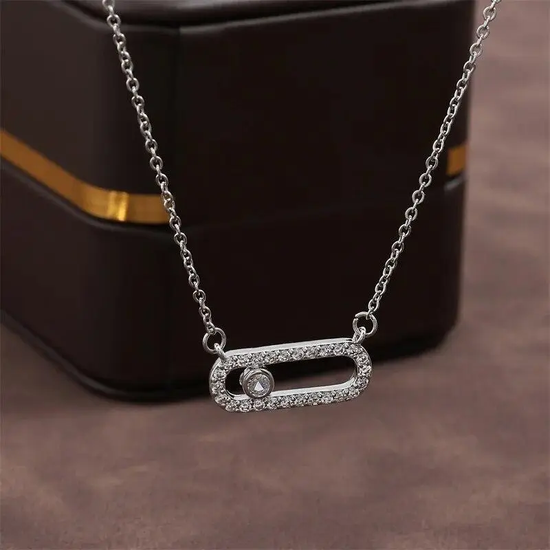 Silver oval pendant set with small stones and a single moving stone inside